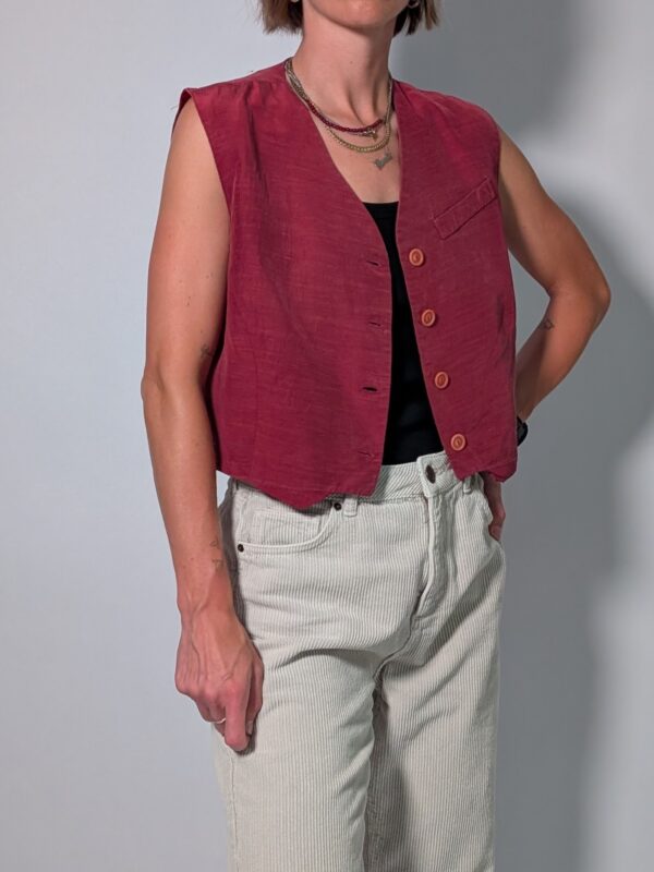 Berry vest 01 Vintage mouwloos gilet in framboosrode tint met V-hals, houten knopen en rechte pasvorm.