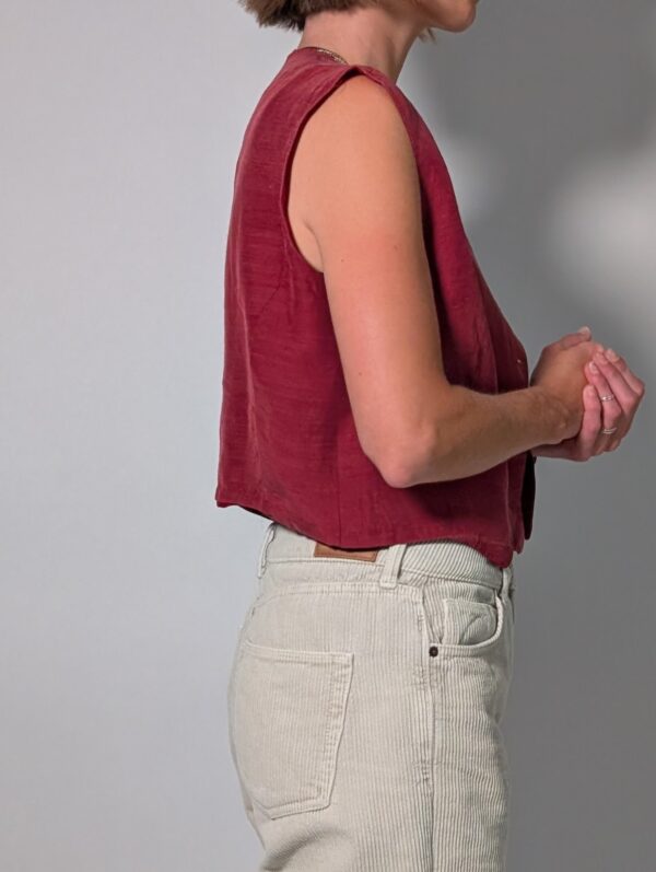 Berry vest 02 Vintage mouwloos gilet in framboosrode tint met V-hals, houten knopen en rechte pasvorm.