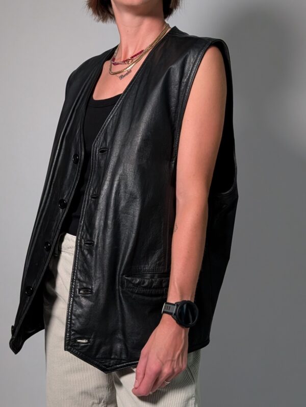 Vintage zwart leren gilet met diepe V-hals, knoopsluiting en langer recht model.