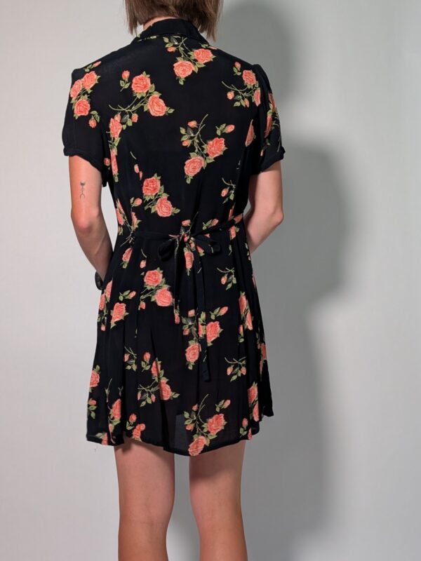Vintage donkerblauwe jurk met korte pofmouwen, knoopsluiting en rozenprint in rood- en groentinten.