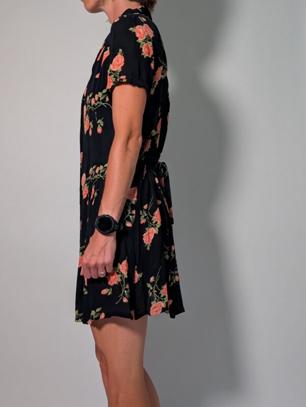 Vintage donkerblauwe jurk met korte pofmouwen, knoopsluiting en rozenprint in rood- en groentinten.
