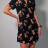 Vintage donkerblauwe jurk met korte pofmouwen, knoopsluiting en rozenprint in rood- en groentinten.