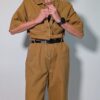 Ochre utility 02 Vintage okerbruine utility jumpsuit met korte mouwen, contrasterende stiksels, borstzakken en wijde pijpen.