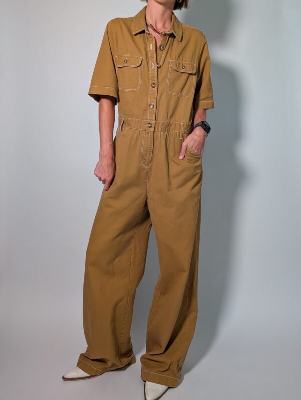 Ochre utility 03 Vintage okerbruine utility jumpsuit met korte mouwen, contrasterende stiksels, borstzakken en wijde pijpen.