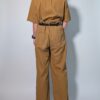 Ochre utility 04 Vintage okerbruine utility jumpsuit met korte mouwen, contrasterende stiksels, borstzakken en wijde pijpen.