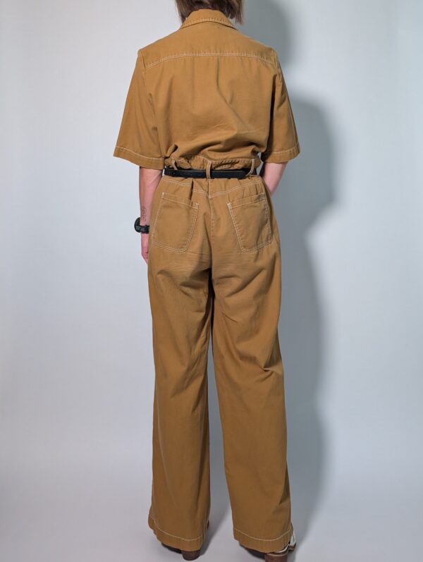 Ochre utility 04 Vintage okerbruine utility jumpsuit met korte mouwen, contrasterende stiksels, borstzakken en wijde pijpen.