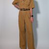 Ochre utility 05 Vintage okerbruine utility jumpsuit met korte mouwen, contrasterende stiksels, borstzakken en wijde pijpen.