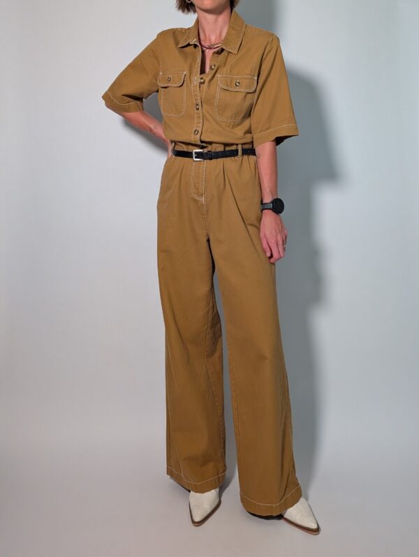 Ochre utility 05 Vintage okerbruine utility jumpsuit met korte mouwen, contrasterende stiksels, borstzakken en wijde pijpen.