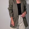 Olive tailor 01 Vintage olijfgrijze blazer met klassieke revers, lange rechte pasvorm en licht oversized silhouet.