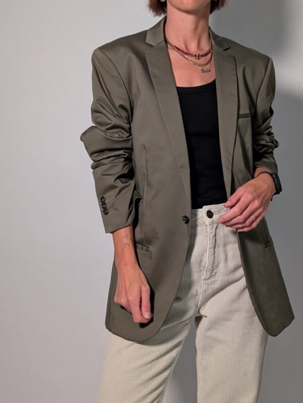 Olive tailor 01 Vintage olijfgrijze blazer met klassieke revers, lange rechte pasvorm en licht oversized silhouet.
