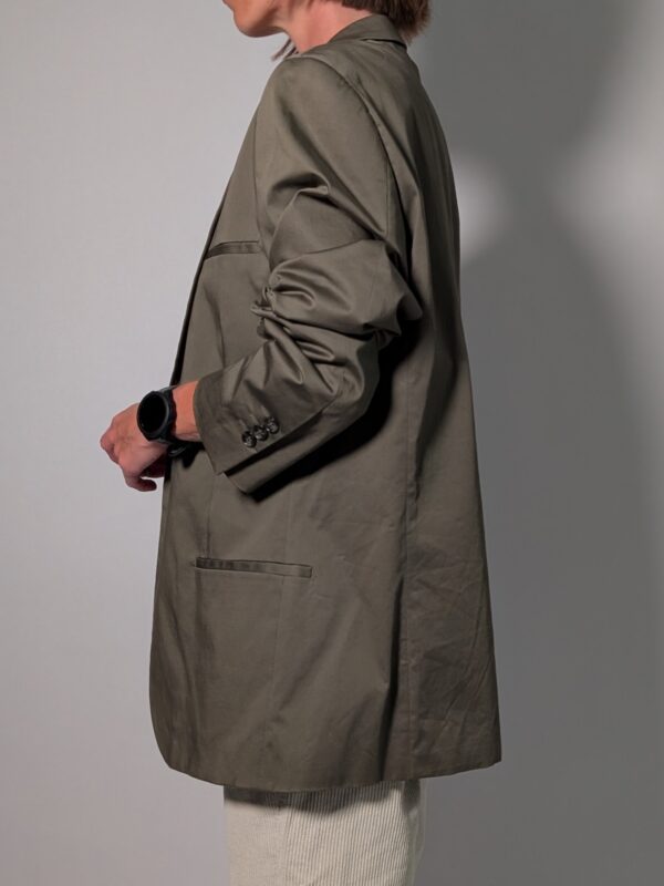 Vintage olijfgrijze blazer met klassieke revers, lange rechte pasvorm en licht oversized silhouet.