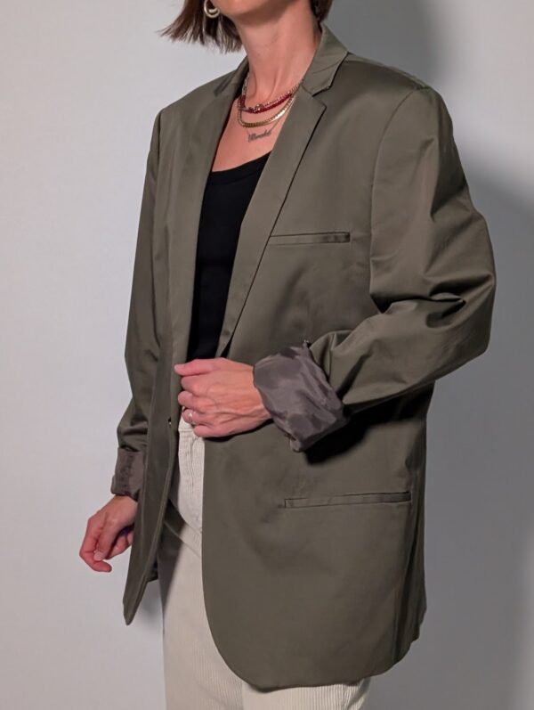 Olive tailor 04 Vintage olijfgrijze blazer met klassieke revers, lange rechte pasvorm en licht oversized silhouet.