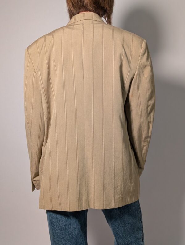 Sand stripe 04 Vintage beige blazer met subtiele verticale glansstrepen, klassieke revers en rechte licht oversized pasvorm.