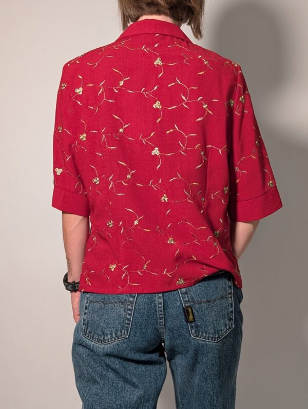 Scarlet stitch 02 Vintage rode blouse met korte mouwen, klassieke kraag en subtiel goudkleurig bloem- en rankborduurwerk.